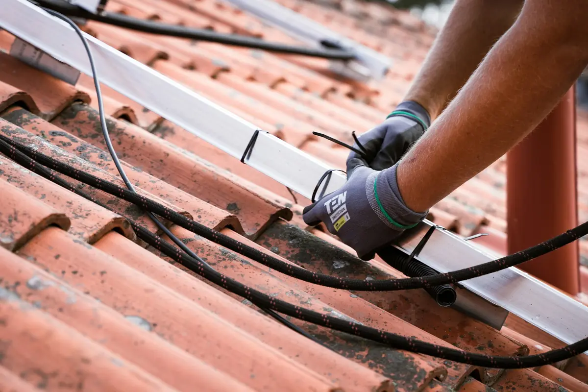 Installer fixing solar rails to a tiled roof