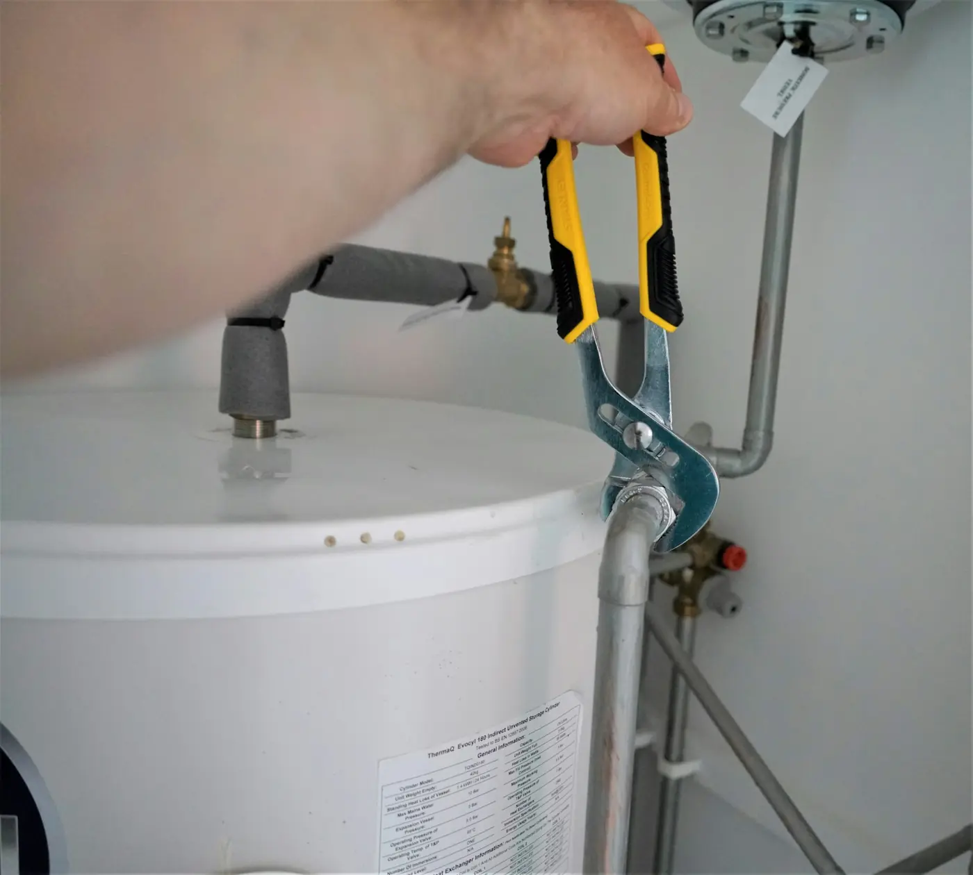 Plumber fitting a valve on a geyser